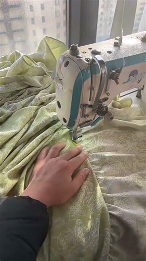 Seamstress Sewing Floral Pattern Fabric Using Electric Sewing Machine