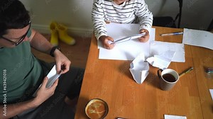 Father and child girl doing origami crafts together. Modern parenthood, weekend education activities at home of parents with children.