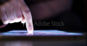 Woman using tablet at night with light from screen. Hand finger swipe and scroll on screen. Woman using tablet for shopping online or social network. Close up 4k footage.