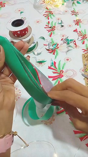 Aprende a realizar un moño para tus regalos con este tutorial. Utilizaremos: -3 metros de cinta de papel, en 3 diferentes colores. -Una Base guia que la puedes hacer con un cartón que mida 16cm de largo (Será el tamaño de nuestro moño) -Un pedazo de cinta para amarrar -Tijeras Recuerda: Tomamos las tres cintas de 3 metros y las unimos, creamos una pestaña de 2 centímetros y desde la pestaña con ayuda de la base guia empezamos a dar 8 vueltas, luego sacamos el moño de la base guia y en la parte d