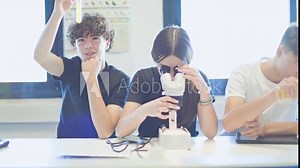 Students conducting experiments with a microscope and test tubes in a science lab.