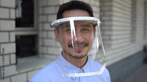 Asian young man wearing face shield for healthcare which is required for doctor and general public to prevent COVID-19.
