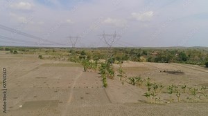 Electricity pylons bearing power supply across rural landscape. aerial view power pylons and high voltage lines java, indonesia.High voltage metal post, tower. Electric Power Transmission Lines over