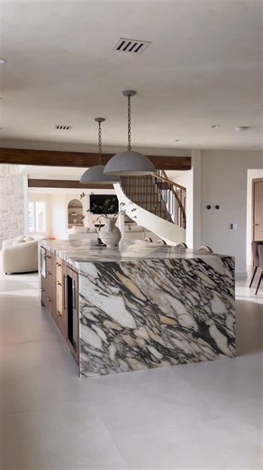 Küche+Cucina | Kitchen Design on Instagram: "Understated luxury at its finest. A monolithic marble island grounds the space, softened by warm wood, curved forms, and a palette made for everyday elegance. Design: @donidouglas_design Kitchen cabinets: @docakitchens @doca_theofficial Alliances: @subzerogroup_miami Marble installation: @lordofmarmi #luxuryinteriors #statementkitchen #marbleisland #customdesign #interiorinspo refinedspaces"
