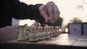 Playing chess in the park at sunset. Pieces on a chessboard.