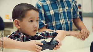 two Asian boy brothers stand next to a humanoid robot and smile. learning the latest robotics by programming method is very easy. development sposobnostei child to mathematics and programming