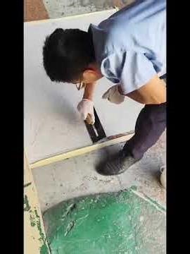 Construction video of Epoxy Floor Coating on a tile with paint and cement on its surface.