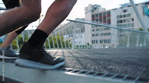 Athletic people running in the street doing intense fitness exercise up the stairs in an urban city. Slow motion closeup of two healthy, active friends jogging in the morning doing cardio workout