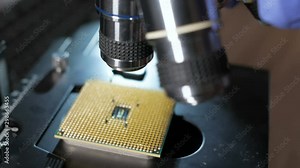 Processor is being examined for apparent defects under microscope. In Modern Electronic Manufacturing Factory Design Engineer Holds Microchip . Close-up a New Generation Microchip. CPU closeup.
