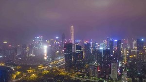 Shenzhen City at Night. Urban Futian District. Guangdong, China. Aerial Time Lapse, Hyper Lapse. Drone Flies Sideways and Upwards