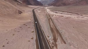 Highway in desert valley with mountains offers scenic landscape for adventurous journey