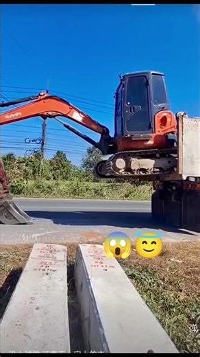 Small excavator loading on a truck without ramps — only pure operator skill!