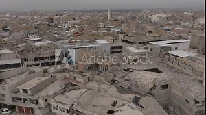 Aerial drone view of Mosul, Iraq: cityscape showcasing war-torn buildings, historic landmarks, and bustling streets, reflecting a blend of resilience and rich cultural heritage