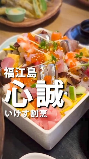 福江島ランチーズ《五島列島グルメメディア》 on Instagram: "本日のオススメディナースポットは、「いけす割烹 心誠」です。 今回ご紹介するのは、以前ランチで伺った「いけす割烹 心誠」へ、久しぶりに伺ってきました。お店は五島市役所から徒歩1〜2分ほどの距離にあり、市役所の駐車場を利用する方が多い立地です。 ランチを紹介した頃から少し時間が経ち、外の看板がリニューアルされていました。五島の魅力的な食材が前面に打ち出されており、入店前から期待が高まります。 自動ドアを開けると、明るい店内とスタッフの元気な声に迎えられました。金曜日ということもあり、テーブル席はほぼ満席。カウンター席と厨房を囲むように席が並び、活気のある雰囲気です。今回は、奥ののれんで仕切られた2人席へ案内していただきました。 入口付近には大きな生け簀があります。上段の水槽には立派な石鯛と伊勢海老が泳ぎ、下の水槽をのぞくと、ひときわ存在感のある大きな黒い魚が目に入りました。五島近海で獲れる高級魚・クエです。お店の方に伺うと、重さはおよそ20キロもあるそうで、クエ鍋にするとお椀で40杯分ほどになるとのこと。 この大き