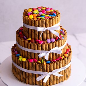 A fun alternative to a loaded KitKat cake. Here we have a 3 tier beast, decorated with smarties and wafer sticks. I have coated mine in Edible luster dust (SweetSticks have a great one that is 100% edible). Having said that, you don't have to add luster dust, this would look just as epic with plain wafer stick pattern :) Buttercream recipe: 300 grams vegetable shortening 300 grams unsalted butter 1.2kg icing sugar 2 tsp vanilla 3 to 4 tablespoons milk | Rosie's Dessert Spot