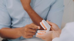 Download Dentist consultation - patient visit at the dental clinic office. Female dentist wearing dentures to explain teeth Recommend guidelines for orthodontics Dentist giving advice on patient's condition. for free