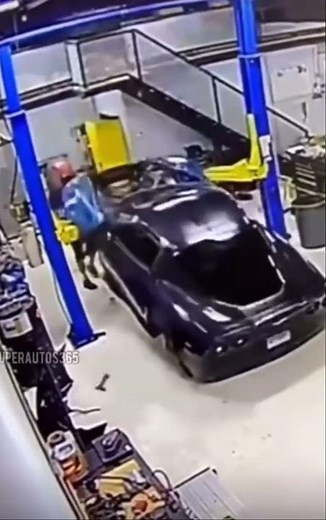 Customers Corvette falls off lift! Worker tries to hold it..