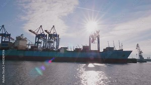 a massive container ship in Hamburg with the Container Gantry Cranes on a sunny day in Hamburg, Germany