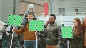 Multicultural diverse crowd of political protesters with green screen chroma key banners. Various people at demonstration with empty space mock up placards. Diverse activists with blanks space signs.