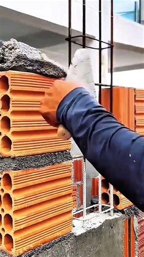 Hand spreads mortar orange blocks stack rebar threads wall rises strength binds