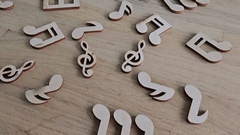 clip-3982919849-exploring-wooden-music-notes-symbols-on-table