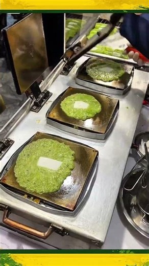 Flattening teflon-baked green dough before it hardens, creating a thin, crispy snack. 🍪🔥