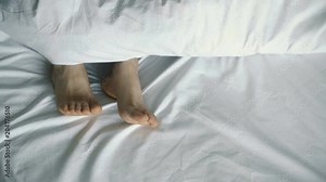 couple in bed. male and female legs from above, white linens. 4k Stock Video