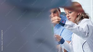 Scientist talking about bio samples with an intern in modern laboratory