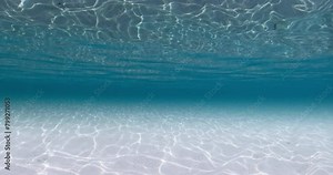 Blue ocean underwater with white sandy bottom and waves. Sea texture