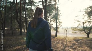 Happy woman hiking in forest. Outdoor adventure enjoying nature. Woman exploring scenic trail. Peaceful forest walk, feeling happy. Hiking lifestyle, woman in nature. Forest hike brings happiness.