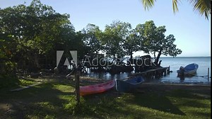 Beach shore in Punta Gorda, Roatan, Honduras with a several marooned small boats, kayak and fishing panga.