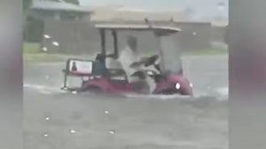Person drives golf cart through flooding in Sun City