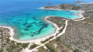 Aerial drone video of tropical paradise exotic island bay covered in limestone trees with emerald crystal clear beach visited by luxury yachts and sail boats in Caribbean destination