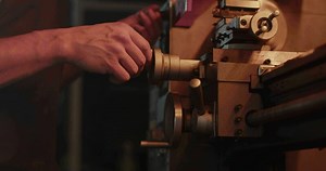Mechanic using lathe for metal processing