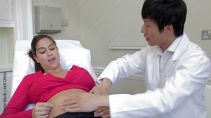 Pregnant Woman Being Given Ante Natal Check By Doctor