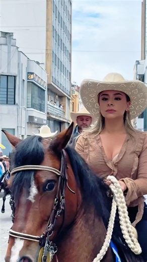 A beautiful lady rides happily at the fair, showing grace and style on her horse.