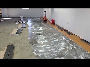 Applying pressure sensitive adhesive and dry time fir glue down LVT installation.