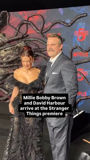 Millie Bobby Brown and David Harbour pose together on the “Stranger Things” red carpet. | E! News
