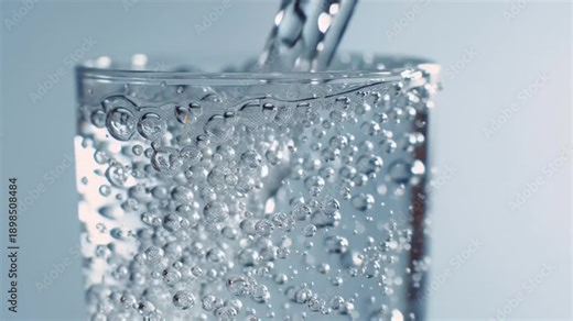 A refreshing glass of water being poured into a clear glass with bubbles on a light blue background video