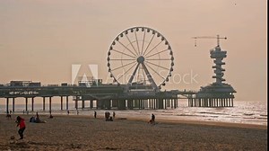 Sunset on the North Sea coast Scheveningen Pier and famous Ferris wheel SkyView de Pier, Den Haag, Netherlands