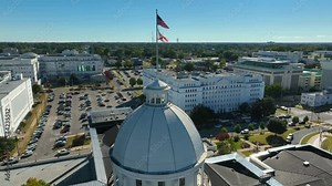 Alabama State Capitol dome in Montgomery AL. Aerial orbit of USA and Alabama flags. Historical home of Confederate States of America.