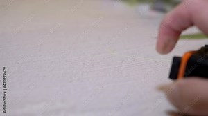 Female Hand Presses Button of an Orange Metallic Tape Measure with a Return Spring. Measuring length, using a Roulette. A mechanism for automatic rewinding tape. Numbers on a double scale. Stock Video