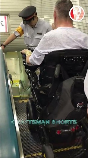 Wheelchair | Subway staff assist wheelchair down escalator