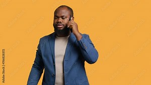 Irked african american man fighting with friends during telephone call, isolated over studio background. Outraged person arguing with mates during conversation on mobile phone, camera A