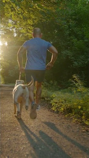 Athlete Running with Dogo Argentino Dog in the Woods