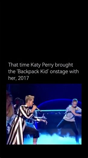 Vintage Iconic on Instagram: "In 2017, Katy Perry brought Russell Horning— better known as the “Backpack Kid”-onstage during her performance of “Swish Swish” on Saturday Night Live. The moment quickly went viral after Horning performed his signature move, the “floss” dance, which involves rapid, rhythmic arm swings with a stiff posture. His deadpan expression, backpack, and unexpected cameo added a humorous and memorable twist to the performance. The appearance significantly boosted the populari