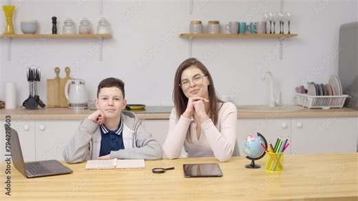 Mom and adult son teach homework at home, mom helps son do homework