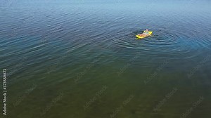 Young woman swims in the lake on an inflatable mattress. Aerial video