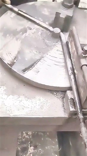 Bending a long metal rod with a specialized machine to create precise curved shape for construction