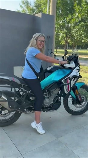Motorcycle Tips Over as Woman Tries to Balance on Driveway